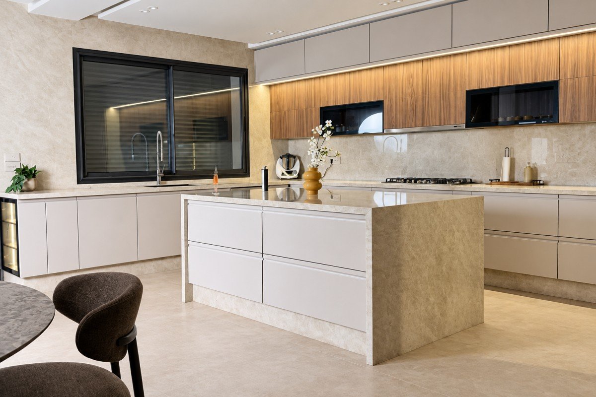 Réalisation INDARI : cuisine claire avec îlot en pierre et façades bois, photo retouchée